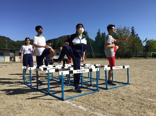 ハードルを使っての準備運動の写真